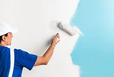 Pintor aplicando rodillo en pared después de una limpieza profunda — servicio complementario de empresa de limpieza en Valencia.